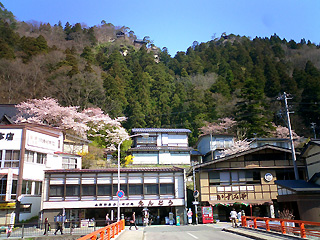 駅前の橋から山寺を見上げる