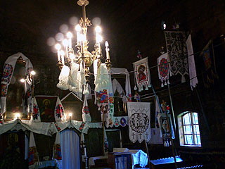 村民が織った美しい布が飾られたブデシュティの木造教会内壁