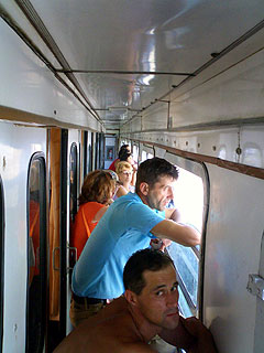 窓を開けた列車の通路にたむろする人々