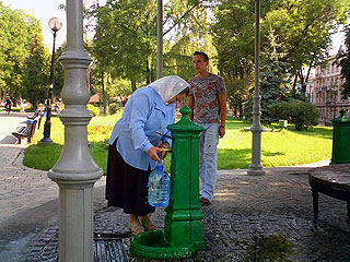 井戸で水を汲むおばあさん