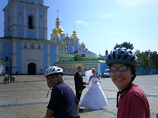 聖ミカエル修道院の広場で花嫁衣装のカップルを背景にパチリ