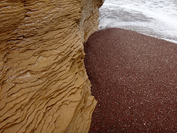 黄土色の崖と赤い砂浜
